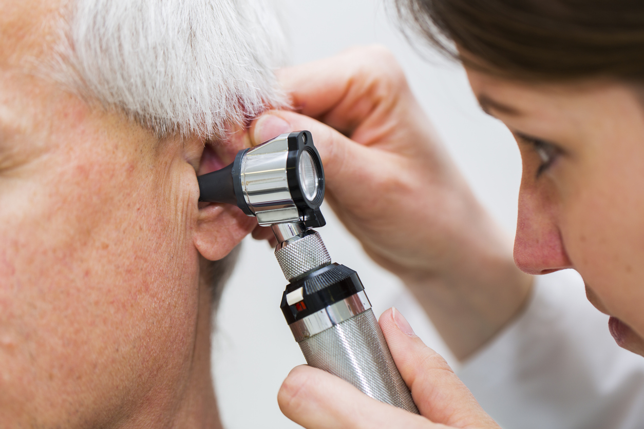Audiologist performing professional ear wax removal