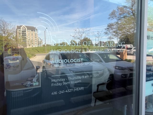 Storefront window at Sense of Hearing Etobicoke showing the clinic hours and contact information